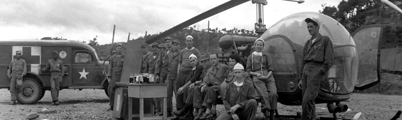 group of medics and soldiers in front of helicopter